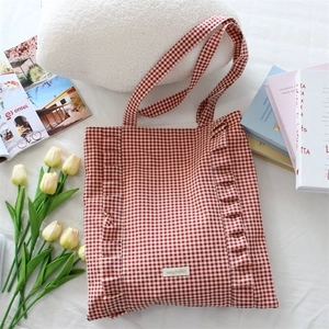 Détail du sac cabas en toile à carreaux rouges avec bords volantés et étiquette mayrabbit