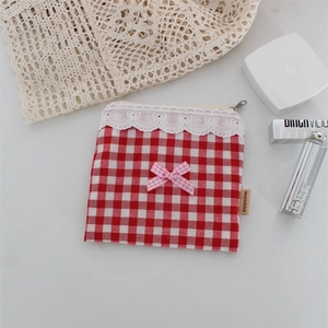 Dettaglio borsa trucco a scacchi rossi con bordo in pizzo e fiocco rosa decorativo