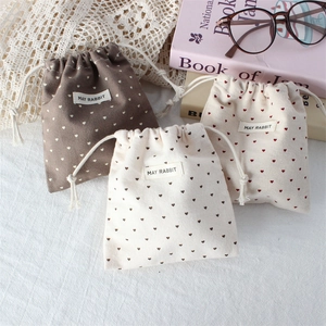 Three-piece heart print cotton drawstring pouches in brown, beige, and white colors
