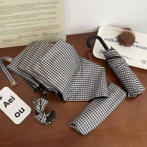 Close-up of black and white checkered umbrella with matte J-shaped hook handle