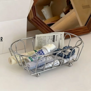 Minimalist silver wire oval storage basket with spherical feet for vanity organization