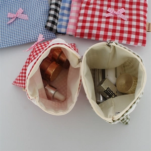Dettaglio di una trousse per cosmetici in cotone a quadretti con pizzo e fiocco carino