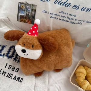 Close-up of soft brown plush dog hot water bottle with festive red polka dot hat