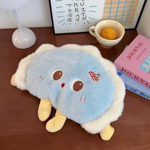Detail of cute blue dumpling plush hand warmer on a cozy wooden desk with home decor