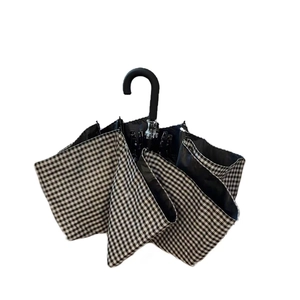 Classic black and white checkered foldable umbrella with an ergonomic black J-shaped handle