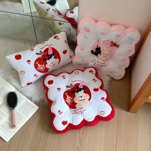 Close-up of cute cartoon bear and cat plush lumbar support cushions on a soft white rug