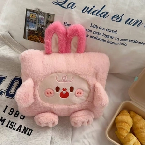 Detail shot of a soft pink plush cartoon rabbit bag with long ears and cute face embroidery