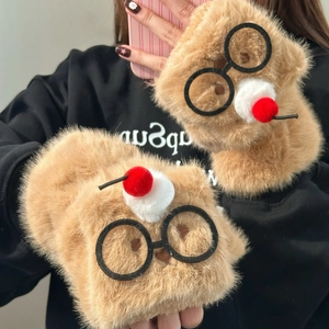 Détail macro de mitaines en peluche marron avec décor de lunettes et pompons doux