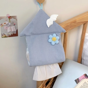 Detail of blue corduroy house-shaped tissue box with white wing and floral embroidery
