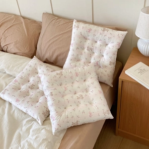 Detail of floral chair cushion with tufted button design and pink bow patterns