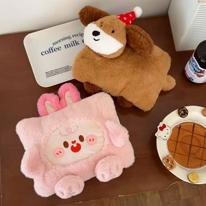 Detail of plush cartoon hot water bottle covers in dog and pig shapes on a table