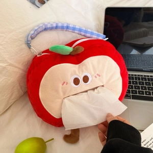 Red apple plush tissue box with cute face and hanging strap on white bedding surface