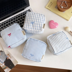 Set of four striped and plaid cotton pouches with cute bow embroidery and zipper closure