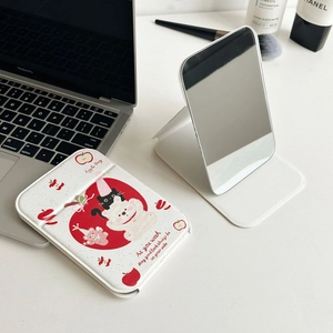 Cute apple bear folding makeup mirror on a white desk with portable support stand