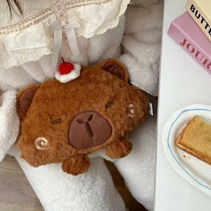 Detail of soft brown plush bear electric hot water bottle held by person in white loungewear