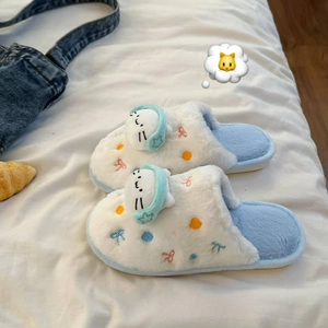 Détail de chaussons chat en peluche avec décor 3D casque sur fond de literie