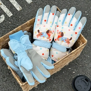Detail of winter ski gloves with cute puppy pattern and adjustable velcro strap cuffs