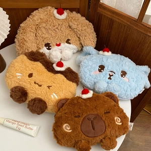 Detail of four cute plush animal hot water bottle covers with cherry accents on wood desk