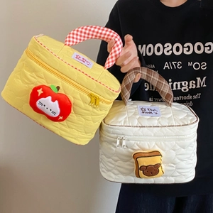Dettaglio borsa trucco trapuntata con cuori, toppa cartoon e manici a quadretti chic