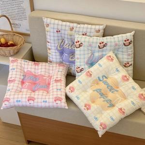 Close-up of checkered quilted chair pads with cute bear and puppy patterns in pastel colors