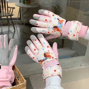 Detail of pink ski gloves showing anti-slip fingertips and cartoon puppy pattern