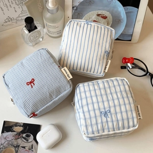 Detail of striped cotton pouch with red bow embroidery and brand woven label