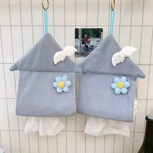 Macro shot of blue corduroy house-shaped tissue holder hanging on a white tiled wall