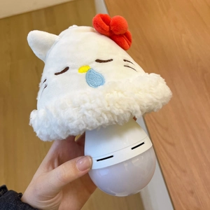 Detail of cartoon plush kitty night light with red bow held by hand for bedroom decor