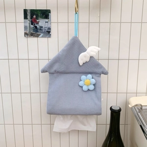Detail of a blue house-shaped corduroy tissue box with wings on a white tiled wall
