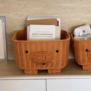 Detail of cute pig-shaped orange woven storage basket with stable supporting feet