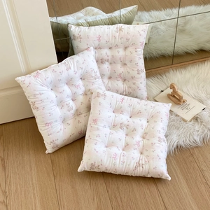 Detailed view of square floral chair cushions with pink bows and rabbit patterns
