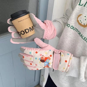 Detail of pink ski gloves with cartoon dog print and adjustable windproof wrist strap