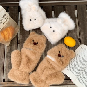 Detailed view of warm plush bear and rabbit mittens on a cozy winter wooden background