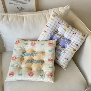 Detail of cute yellow puppy and purple bear plaid cushions on a white sofa decor