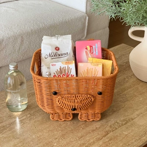 Detail of bear-shaped woven storage basket filled with various snacks on a desktop