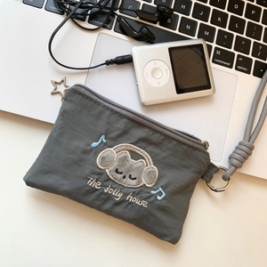 Detail shot of a grey cat card holder with embroidery on a white laptop keyboard