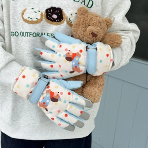 Detail of cartoon puppy ski gloves with adjustable wrist strap and warm fleece lining