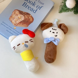 Detail view of cute plush baby rattles with cat and dog designs on a minimal background