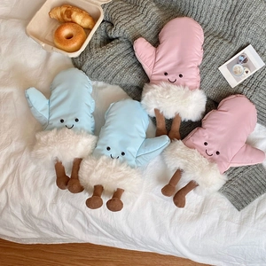 Detail of plush paw-shaped cushions with embroidered smiling faces in pink and blue colors