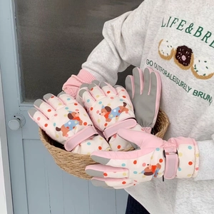 Detailed view of pink cartoon dog ski gloves with adjustable straps and touchscreen tips