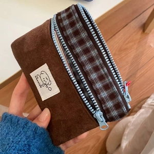 Brown suede dual-layer card wallet with check pattern and blue zipper held in hand