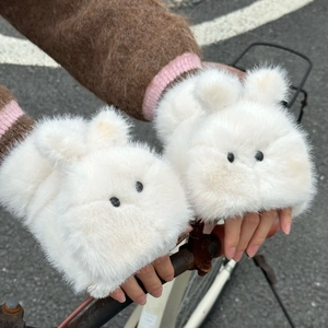 First-person view of white plush bunny fingerless gloves on bicycle handlebars