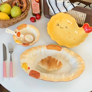 Detail of warm yellow ceramic tableware set with embossed croissant motifs and wavy edges
