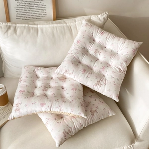 Detail of floral chair cushions with lace trim and nine-hole quilting in cozy setting