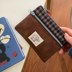 Detailed texture of brown corduroy coin purse with blue zipper and blue plaid ribbon