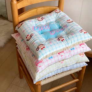 Detailed view of four fluffy checkered seat cushions with cute cartoon bear and cat prints