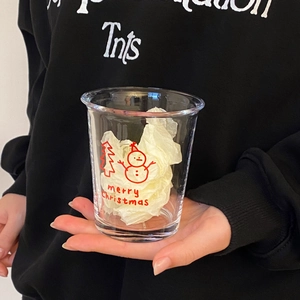 Close-up of Christmas snowman glass cup with festive red prints and Merry Christmas text