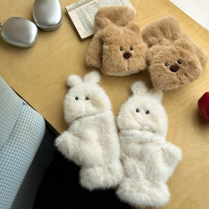 Flat lay of cute plush bear and bunny convertible gloves on a wooden desk with accessories