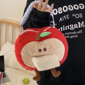 Detail of red apple plush tissue holder with checkered handle and cartoon eyes