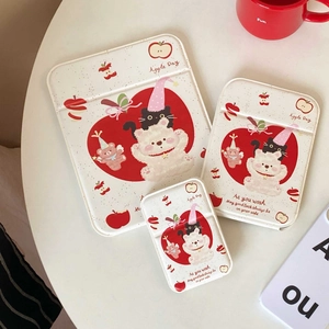 Three sizes of padded tablet sleeves with cute bear and apple illustrations on a white desk